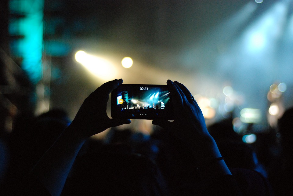 Fan taking video with phone during concert